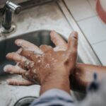 Hygiene - person in white shirt washing hands