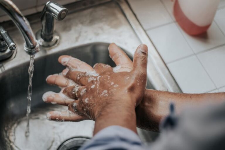 Hygiene - person in white shirt washing hands