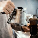 AeroPress - person holding stainless steel teapot
