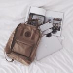 Essentials - silver ipad beside brown leather handbag