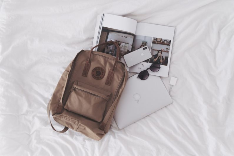 Essentials - silver ipad beside brown leather handbag