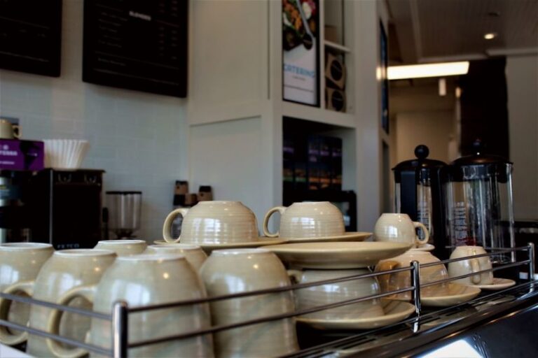 Best Coffeehouse - white ceramic mugs on stainless steel rack
